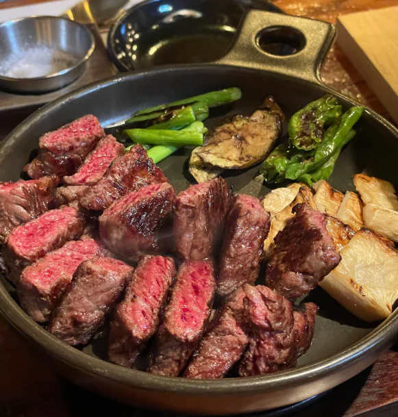 검은 칠기 함을 배경으로 무쇠 팬에 담은 구운 한우